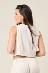 Chaleco negro cropped de lino, con escote en V y cierre frontal con botones.