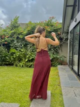 Vestido largo negro con escote en V, cut outs laterales bajo el busto y breteles finos cruzados y atados en la espalda.