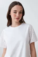 Remera blanca de algodón con mangas cortas con detalle de broderie calado.