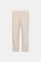 Pantalón de vestir color beige, de tiro alto, corte recto y largo cropped.