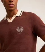 Camisa polo marrón con textura, cuello con detalle contrastante en beige y logo bordado en el pecho.