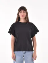Remera negra de manga corta con detalle de calado en forma de mariposa en las mangas.