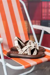 Sandalias chatas con base marrón y tiras cruzadas de cuero con estampado animal print de vaca.