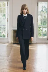 Blazer de lana azul marino con cuello solapa de muescas y manga larga acabada en abertura y botones. Tiene bolsillos con solapa en delantero y de vivo en pecho, forro interior a tono y cierre frontal cruzado con botones.