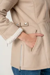 Campera color visón confeccionada en cuero ovino con interior de borrego sintético. Tiene capucha desmontable, cierre frontal con cremallera y bolsillos laterales.