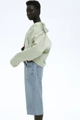 Bermuda de denim celeste, corte recto, tiro bajo y largo a la rodilla.