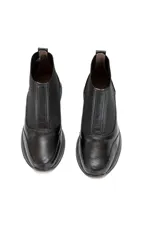 Botín Chelsea negro de cuero vacuno liso con inserciones elásticas laterales y detalle texturizado en el talón.