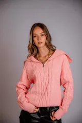 Buzo de punto color rosado, con cuello polo y cierre frontal parcial, de manga larga y diseño holgado.