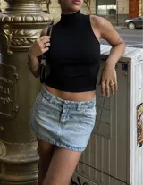 Minifalda de jean celeste con efecto lavado, tiro bajo y bolsillos delanteros y traseros.