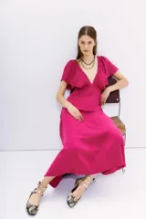 Vestido midi fucsia con escote en V, mangas cortas amplias, espalda cuadrada y cintura elastizada.
