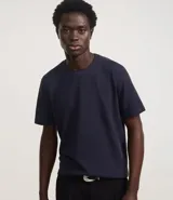 Remera azul marino de corte regular, confeccionada en tejido de piqué de algodón. Tiene cuello redondo con rib, mangas cortas y diseño liso.