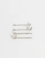Set de cuatro horquillas doradas para el pelo, dos con apliques de mariposa y dos con apliques de strass.