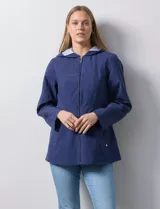 Campera impermeable azul con cierre central, bolsillos delanteros y lazo de ajuste en la cintura. Tiene avíos metálicos plateados y cierre oculto en la espalda para autoguardado.