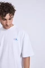 Remera blanca de corte holgado con pequeño estampado en el pecho.