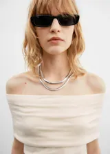 Vestido color crema con escote off-shoulder y diseño drapeado.