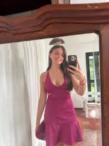 Vestido corto de lentejuelas color verde oliva, con escote en V, breteles finos cruzados en la espalda, cut-outs laterales y volado en el ruedo.