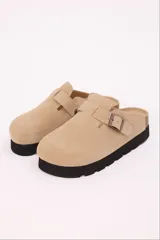Zuecos color marrón claro de símil gamuza, con base de goma negra y hebilla regulable.