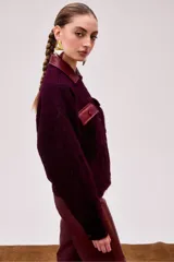 Chaqueta corta color burdeo confeccionada en alpaca y lana merino, con cuello y bolsillos de cuero.