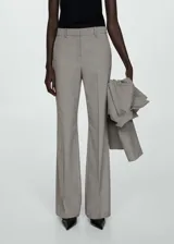 Pantalón de vestir gris con corte acampanado, tiro alto, bolsillos laterales y cierre oculto con botón, gancho y cremallera.