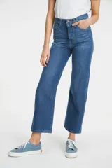 Jeans de tiro alto color azul medio, corte recto y largo al tobillo. Cierre con botones.