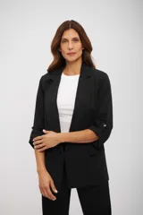 Blazer negro de corte relajado, con solapas de muesca y mangas tres cuartos ajustables con trabilla y botón metálico.