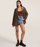 Blusa blanca de punto roma, con diseño de cuello halter que deja la espalda descubierta.