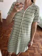 Camisón corto verde con rayas horizontales blancas, cuello redondo con abertura en V y botones. Manga corta.
