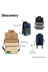 Mochila cilíndrica tipo matera, con dos compartimentos separados por cierre. El cuerpo superior es de material liso color camel y el inferior es acolchado color beige. Presenta parches circulares con motivos de naturaleza y una etiqueta verde con el texto "EXPLORE YOUR WORLD: Discovery".