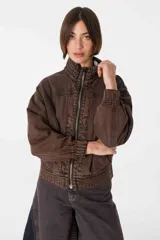 Campera tipo bomber de jean negro con cierre frontal dorado, bolsillos laterales y cuello alto. Tiene mangas largas con puños elastizados y detalles de costuras a contratono en cuello y pretina.