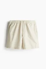 Short color crema de lona de algodón suave, con cintura elástica con cordón para ajustar, bolsillos al bies y un bolsillo insertado atrás. Corte estándar.