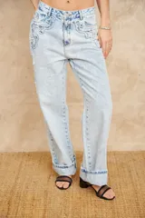 Pantalón de jean celeste de corte ancho con apliques bordados y desflecados.