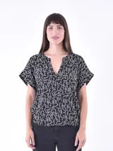 Blusa negra con estampado de ramas en color crema, escote en V y mangas cortas con dobladillo.
