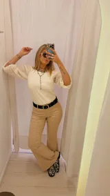 Pantalón de vestir color beige, de tiro alto, corte recto y terminación acampanada.