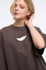 Remera blanca de algodón con cuello redondo y manga corta. Estampado pequeño de un ají rojo en el centro del pecho.