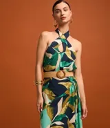 Blusa sin mangas con escote halter, estampado de follaje en tonos verde, azul y beige, y cinturón marrón.