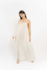 Vestido largo color crema, de corte suelto y breteles finos.