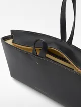 Mini bolso negro de piel bovina con asa de mano.