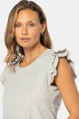 Remera color beige con estampado de hojas en verde claro, cuello redondo y mangas cortas con volados.