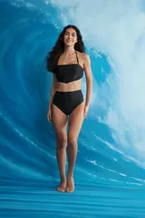 Top bandeau negro con tirantes finos ajustables y corte triangular en el centro.