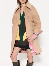 Tapado de paño color beige con flecos en la parte superior y broches al tono. Forrería estampada con print de monas. Diseño de la colaboración entre Jazmin Chebar y Edgardo Giménez.