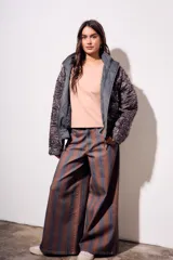 Pantalón de jean tiro medio, corte wide leg, confeccionado en tela de algodón con rayas verticales marrones y azules.