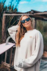 Buzo color crema de corte clásico y tejido acanalado.