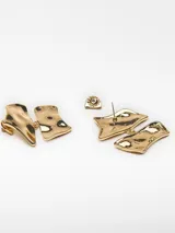 Par de aros colgantes dorados con forma geométrica irregular y textura martillada.