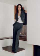 Pantalón de vestir gris marengo, de corte recto y tiro medio, con pinzas delanteras, bolsillos laterales y cierre frontal oculto con botón, gancho y cremallera.
