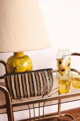 Bolso tipo bandolera, tejido en cuero color bordó, amarillo y blanco.