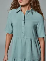 Vestido verde musgo con cuello camisero, manga corta y corte evasé.