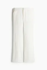 Pantalón sastrero de lino color blanco, de corte acampanado, tiro medio, cierre frontal con botón y bolsillos laterales.