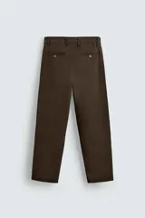 Pantalón chino color beige, de corte recto y tiro medio. Confeccionado en tejido de algodón con elasticidad, con bolsillos laterales y traseros de vivo. Cierre frontal con cremallera y botón.