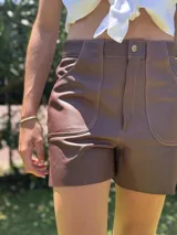 Short de cuero color chocolate con costuras en contraste color naranja.