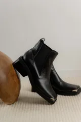 Botas Chelsea de cuero color marrón con elástico lateral negro, puntera metálica cuadrada y suela track.